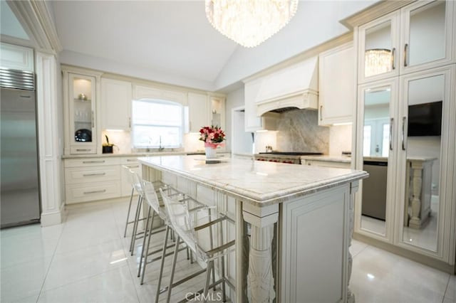 1281 E Orange Grove Blvd, Pasadena, CA 91104 - kitchen featuring built in fridge, light tile patterned floors, custom range hood, a kitchen island, and vaulted ceiling