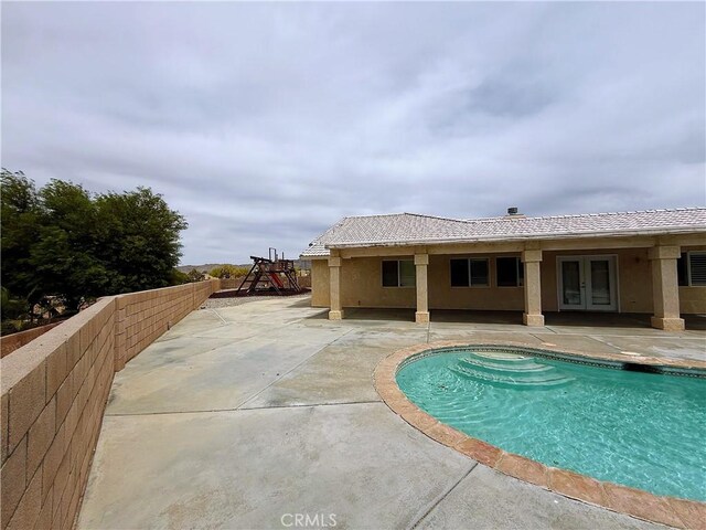 8520 Bolero Dr, Yucca Valley, CA 92284 - view of pool featuring french doors, a patio area, and a playground