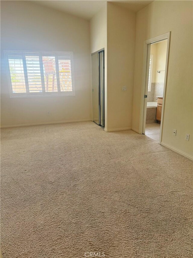 8520 Bolero Dr, Yucca Valley, CA 92284 - unfurnished bedroom with a closet, light carpet, ensuite bathroom, and baseboards
