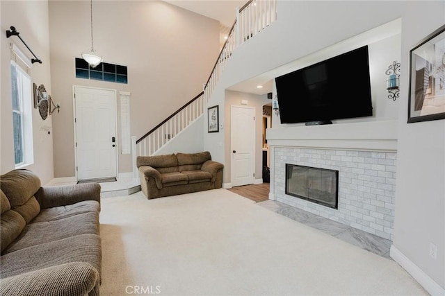 20019 Franks Way, Saugus, CA 91350 - carpeted living area with stairway, a towering ceiling, a brick fireplace, and baseboards
