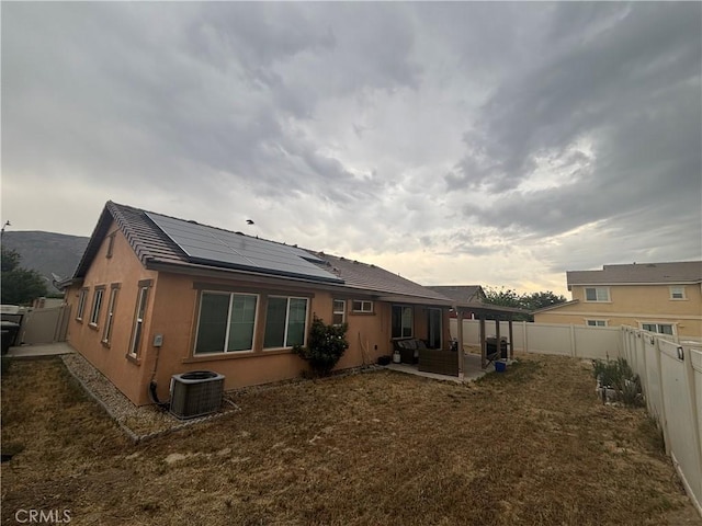 1884 Glow Pointe, San Jacinto, CA 92582 - back of house featuring roof mounted solar panels, a fenced backyard, central AC, a patio area, and outdoor lounge area