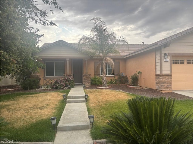 1884 Glow Pointe, San Jacinto, CA 92582 - view of front facade featuring a front yard, a garage, stucco siding, and stone siding