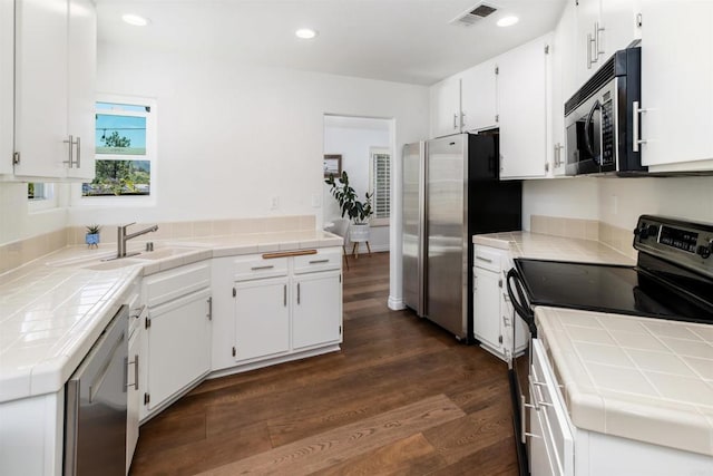 6848 Xana Way, Carlsbad, CA 92009 - kitchen with appliances with stainless steel finishes, tile counters, dark wood-style flooring, white cabinets, and a sink