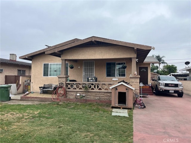 2730 Walnut St, Huntington Park, CA 90255 - view of front of property with covered porch, stucco siding, and a front lawn