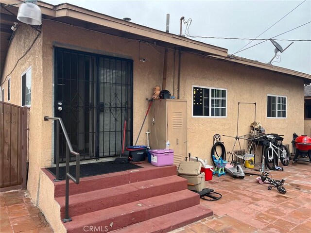 2730 Walnut St, Huntington Park, CA 90255 - doorway to property with stucco siding and a patio area