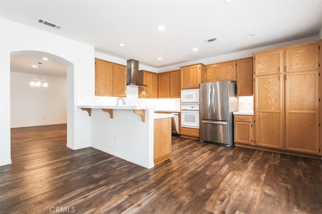 1171 Otano Way, Oxnard, CA 93030 - kitchen featuring stainless steel appliances, wall chimney exhaust hood, arched walkways, a peninsula, and a breakfast bar
