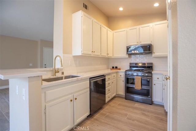 369 Chaumont Cir, Lake Forest, CA 92610 - kitchen featuring appliances with stainless steel finishes, backsplash, a peninsula, white cabinets, and light wood-style flooring