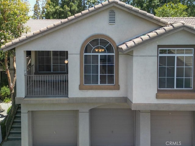 369 Chaumont Cir, Lake Forest, CA 92610 - view of side of property with an attached garage, stucco siding, and a tiled roof