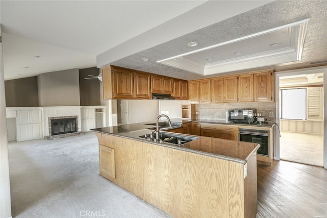 19355 Tomahawk Rd, Apple Valley, CA 92307 - kitchen with oven, a sink, a peninsula, a raised ceiling, and ornamental molding