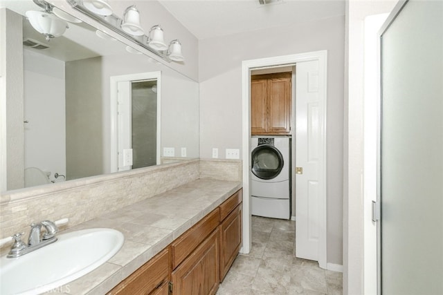 19355 Tomahawk Rd, Apple Valley, CA 92307 - bathroom featuring washer / clothes dryer, vanity, decorative backsplash, and tile patterned floors