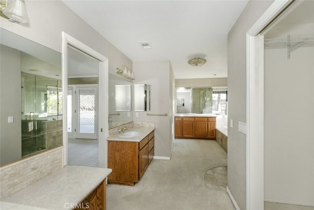 19355 Tomahawk Rd, Apple Valley, CA 92307 - bathroom with two vanities, a garden tub, baseboards, and a shower with door