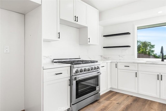 1563 Gary Ln, Redlands, CA 92374 - kitchen with high end stove, a sink, white cabinetry, light stone countertops, and light wood finished floors