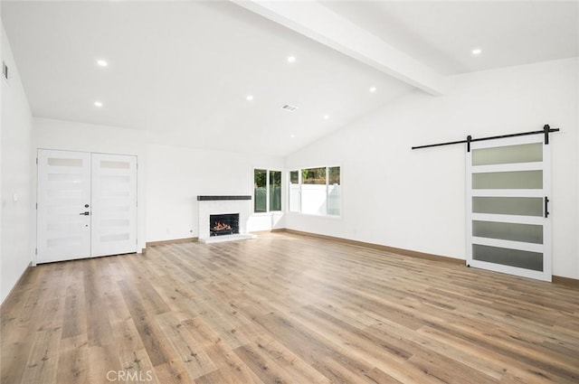 1563 Gary Ln, Redlands, CA 92374 - unfurnished living room with light wood finished floors, a barn door, a lit fireplace, recessed lighting, and baseboards