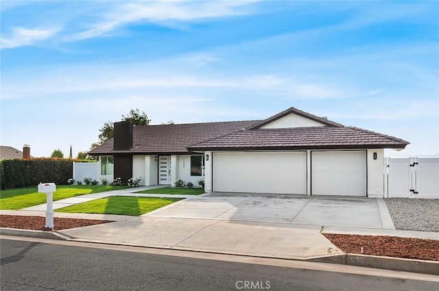 1563 Gary Ln, Redlands, CA 92374 - ranch-style home with driveway, a gate, an attached garage, a tile roof, and stucco siding