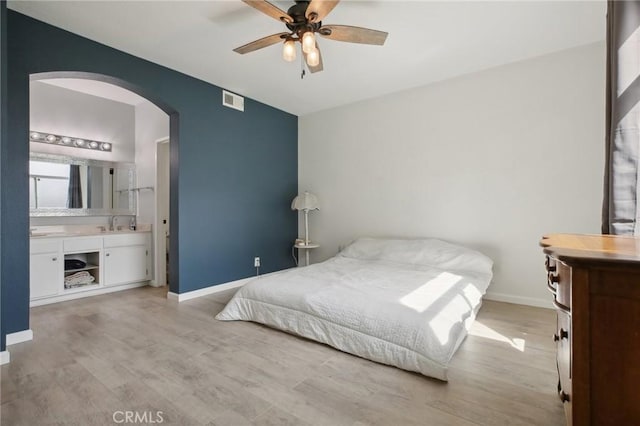 30902 Clubhouse Dr Unit 27D, Laguna Niguel, CA 92677 - bedroom with arched walkways, light wood-style floors, connected bathroom, and a ceiling fan