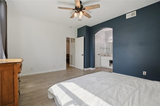 30902 Clubhouse Dr Unit 27D, Laguna Niguel, CA 92677 - bedroom featuring arched walkways, wood finished floors, ensuite bathroom, and a ceiling fan