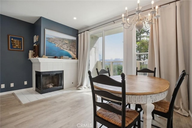 30902 Clubhouse Dr Unit 27D, Laguna Niguel, CA 92677 - dining room featuring wood finished floors, a chandelier, a tiled fireplace, baseboards, and recessed lighting