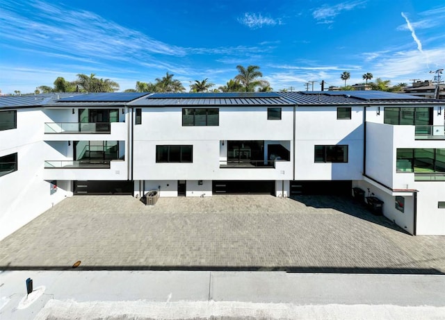 164 Cherry Ave, Carlsbad, CA 92008 - rear view of property with solar panels, stucco siding, a metal roof, and a balcony