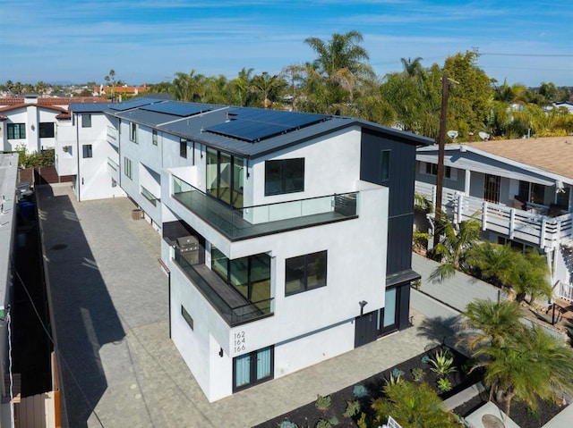 164 Cherry Ave, Carlsbad, CA 92008 - view of property exterior featuring a balcony, stucco siding, and solar panels