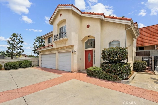609 E Newmark Ave, Monterey Park, CA 91755 - mediterranean / spanish home with a balcony, stucco siding, an attached garage, a tiled roof, and concrete driveway