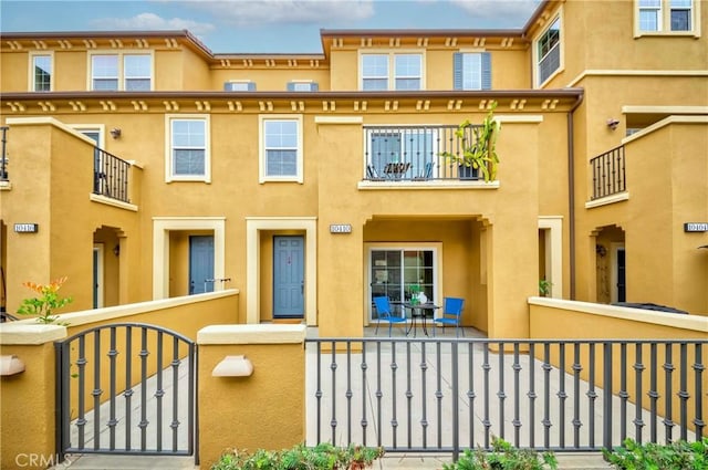 10410 Orchid Way, Santa Fe Springs, CA 90670 - view of front of house with a fenced front yard, stucco siding, a gate, and a balcony