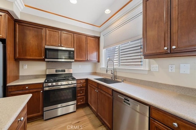11506 Cuervo Way, Atascadero, CA 93422 - kitchen featuring stainless steel appliances, a sink, light countertops, light wood finished floors, and ornamental molding
