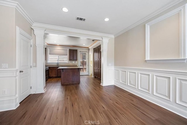 11506 Cuervo Way, Atascadero, CA 93422 - kitchen featuring ornate columns, a center island, dark wood-type flooring, a decorative wall, and crown molding