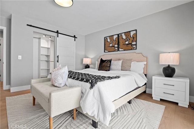 2014 Cumberland Rd, Glendora, CA 91741 - bedroom featuring a barn door, wood finished floors, and baseboards