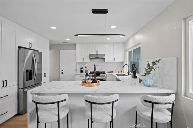 2014 Cumberland Rd, Glendora, CA 91741 - kitchen featuring appliances with stainless steel finishes, under cabinet range hood, a sink, a peninsula, and a breakfast bar area