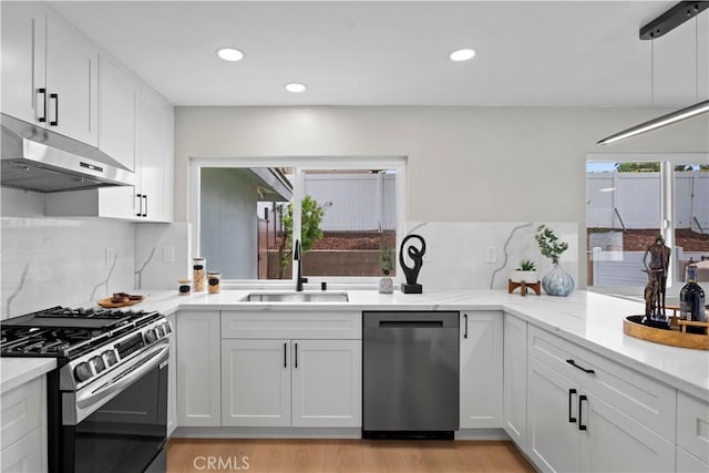 2014 Cumberland Rd, Glendora, CA 91741 - kitchen featuring appliances with stainless steel finishes, under cabinet range hood, a sink, tasteful backsplash, and white cabinets