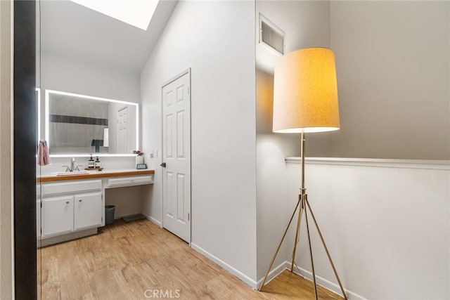 4140 Workman Mill Rd Unit 188, Whittier, CA 90601 - bathroom with wood finished floors, vanity, a skylight, and baseboards
