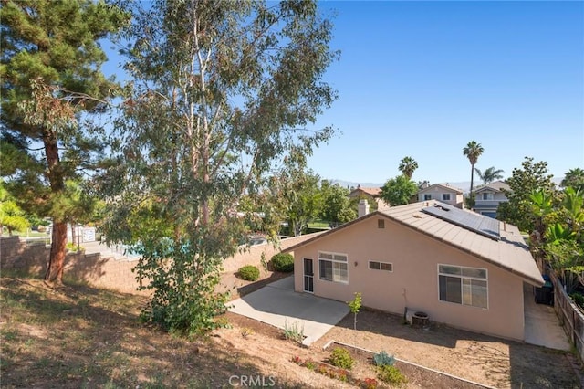 1324 Soundview Cir, Corona, CA 92881 - back of house with stucco siding, a patio, solar panels, metal roof, and a standing seam roof