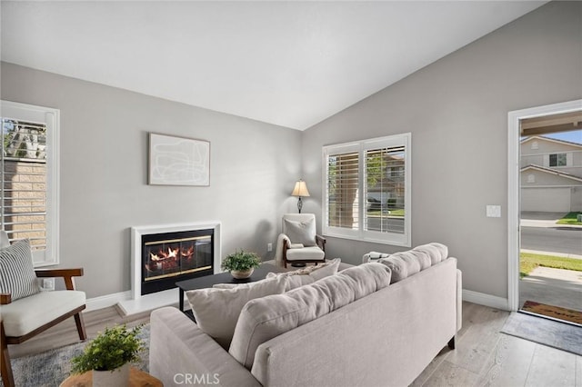 1324 Soundview Cir, Corona, CA 92881 - living area featuring lofted ceiling, a glass covered fireplace, baseboards, and plenty of natural light