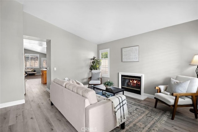 1324 Soundview Cir, Corona, CA 92881 - living room featuring lofted ceiling, a glass covered fireplace, light wood-type flooring, and baseboards