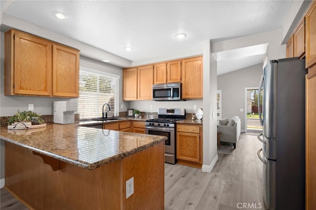 1324 Soundview Cir, Corona, CA 92881 - kitchen with appliances with stainless steel finishes, a peninsula, a sink, light wood-style flooring, and stone counters
