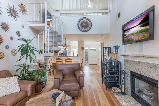 25847 Mcbean Pkwy Unit 25, Valencia, CA 91355 - living room featuring stairway, wood finished floors, a fireplace, and a high ceiling