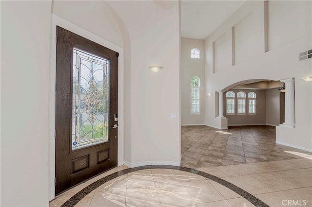 211 Franklin Ave, Redlands, CA 92373 - entryway with inlaid floor details, decorative columns, baseboards, arched walkways, and a high ceiling