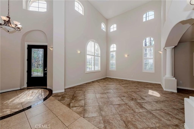 211 Franklin Ave, Redlands, CA 92373 - foyer entrance with a high ceiling, a chandelier, decorative columns, baseboards, and arched walkways