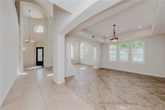 211 Franklin Ave, Redlands, CA 92373 - unfurnished living room featuring plenty of natural light, arched walkways, and a chandelier