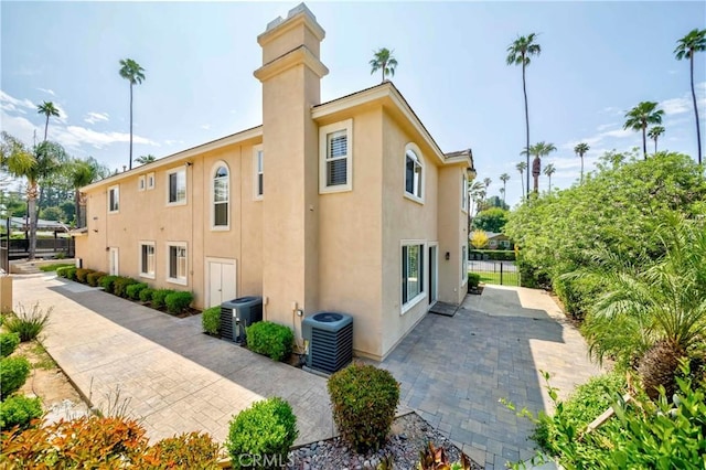 211 Franklin Ave, Redlands, CA 92373 - view of home's exterior with cooling unit, stucco siding, a patio, and a chimney