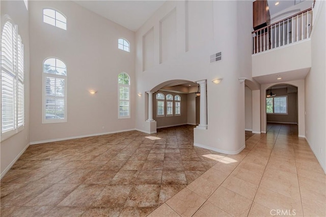 211 Franklin Ave, Redlands, CA 92373 - foyer entrance with ornate columns, arched walkways, a towering ceiling, and baseboards