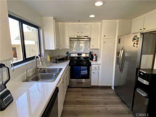 17722 Sergio Cir Unit 203, Huntington Beach, CA 92647 - kitchen featuring appliances with stainless steel finishes, under cabinet range hood, a sink, white cabinets, and light countertops