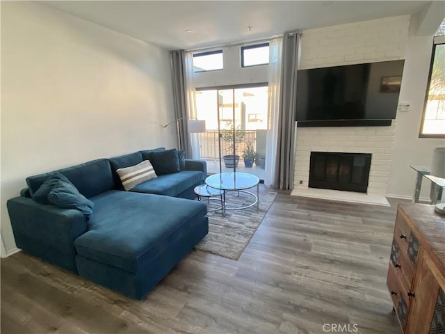 17722 Sergio Cir Unit 203, Huntington Beach, CA 92647 - living area featuring wood finished floors, a brick fireplace, and baseboards