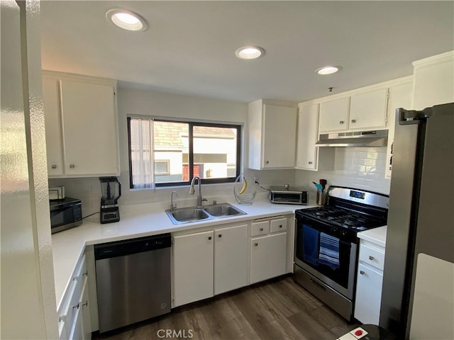 17722 Sergio Cir Unit 203, Huntington Beach, CA 92647 - kitchen with stainless steel appliances, under cabinet range hood, a sink, white cabinets, and light countertops
