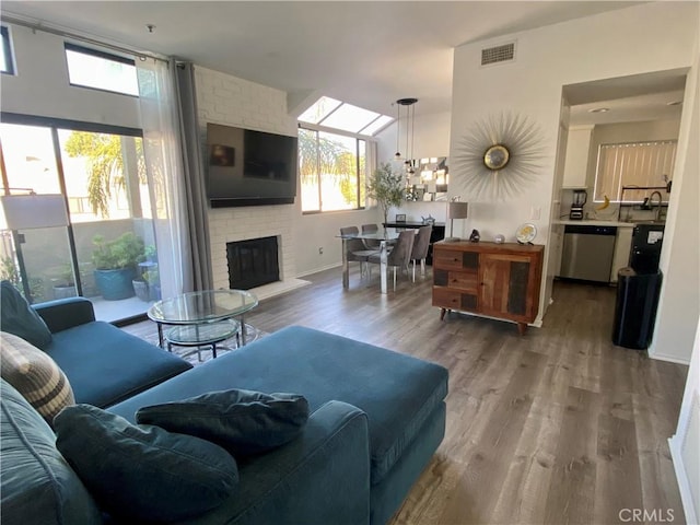 17722 Sergio Cir Unit 203, Huntington Beach, CA 92647 - living room featuring plenty of natural light, a chandelier, wood finished floors, and a fireplace