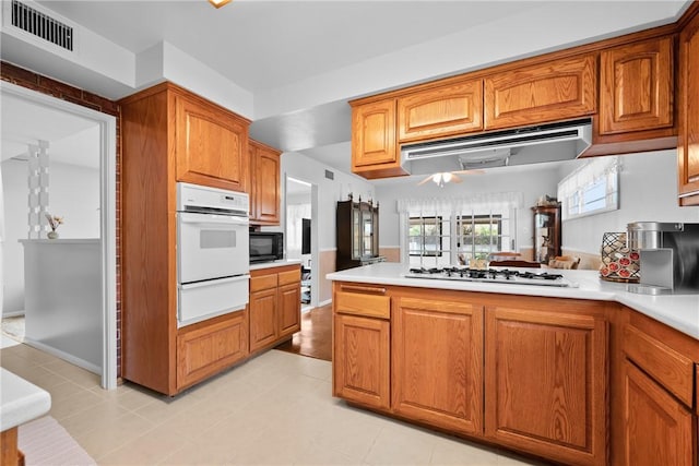 1426 E Colver Pl, Covina, CA 91724 - kitchen featuring a warming drawer, white appliances, range hood, light countertops, and brown cabinets