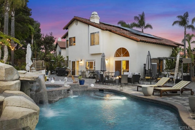4520 Tarantella Ln, San Diego, CA 92130 - back of property featuring solar panels, a patio, a chimney, stucco siding, and an outdoor hangout area