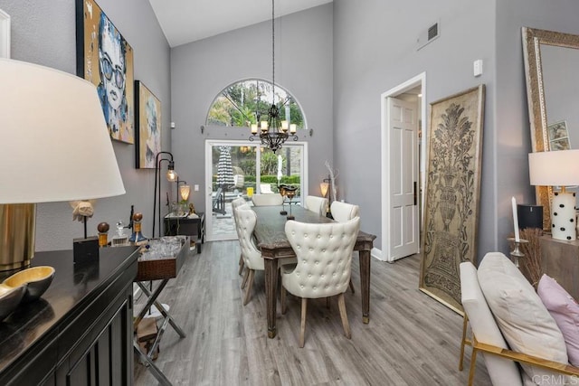 4520 Tarantella Ln, San Diego, CA 92130 - dining area with a towering ceiling, a chandelier, and light wood finished floors