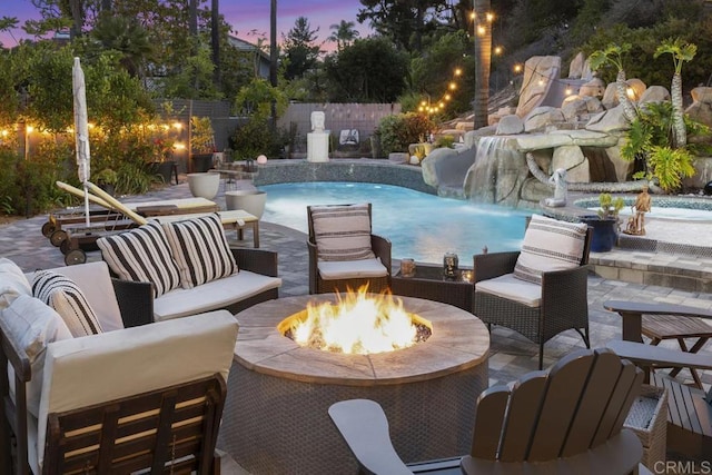 4520 Tarantella Ln, San Diego, CA 92130 - pool at dusk with an outdoor living space with a fire pit, a patio area, and a fenced backyard