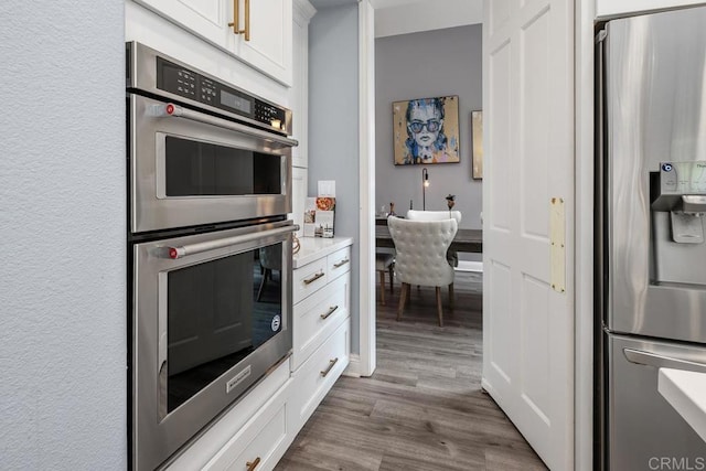 4520 Tarantella Ln, San Diego, CA 92130 - kitchen featuring stainless steel appliances, white cabinets, dark wood-style floors, and light countertops